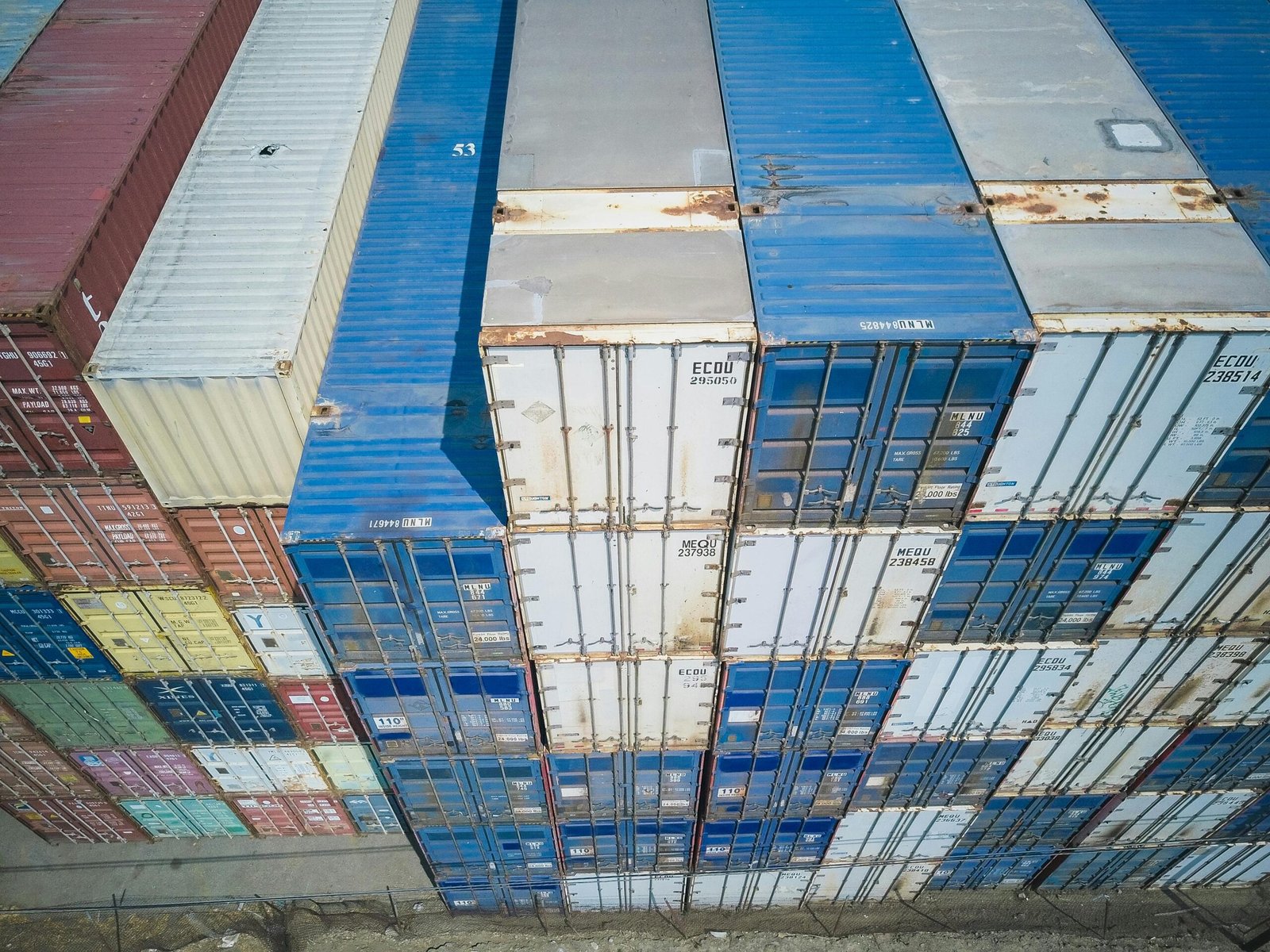 Aerial view showing colorful stacked cargo containers at a shipping yard.